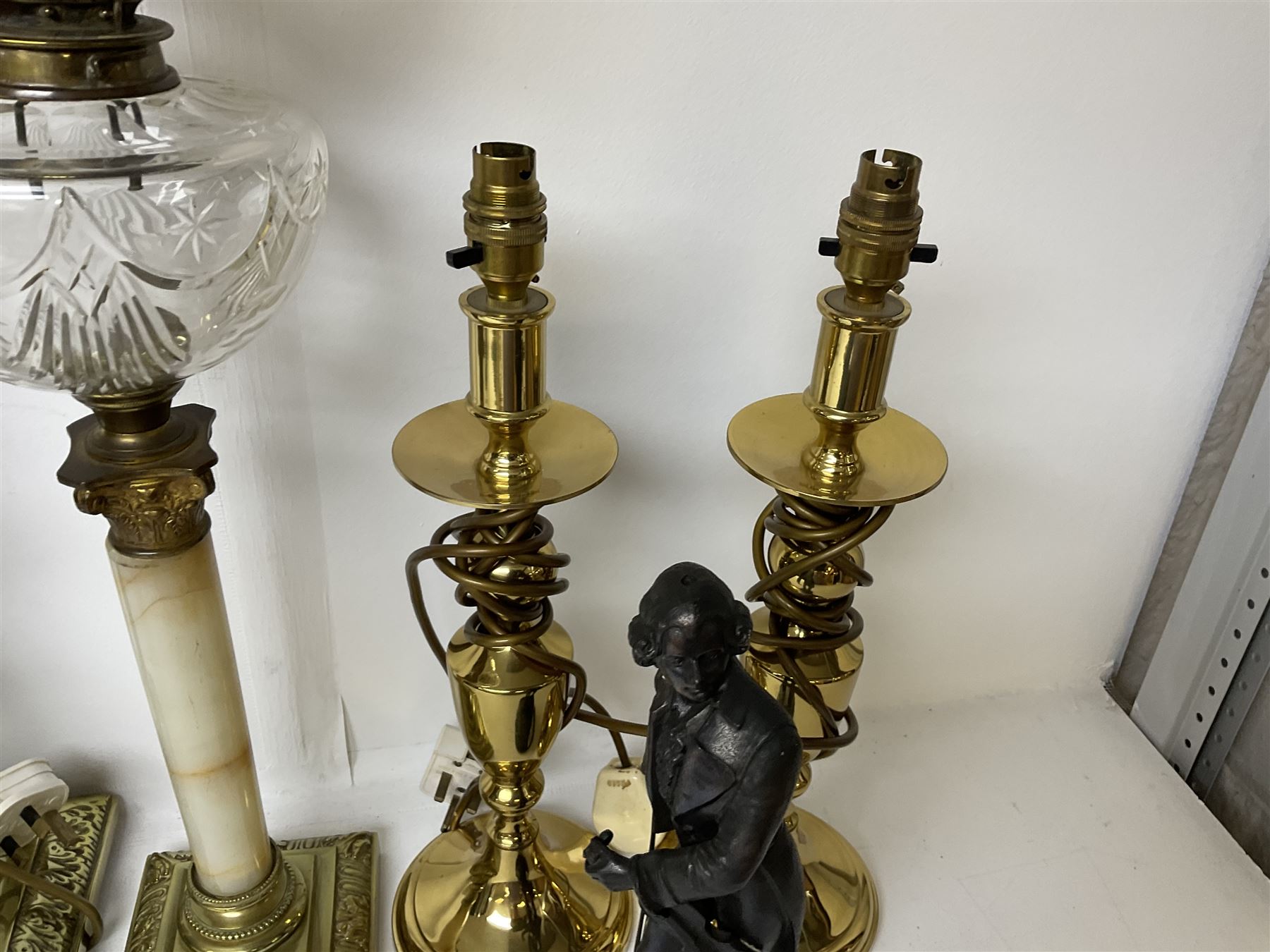 Oil lamp with frosted floral shade and cut glass reservoir, upon cast brass and marble base, together with a cast brass Corinthian column table lamp, pair of brass table lamps and a composite metal figure of a violinist 