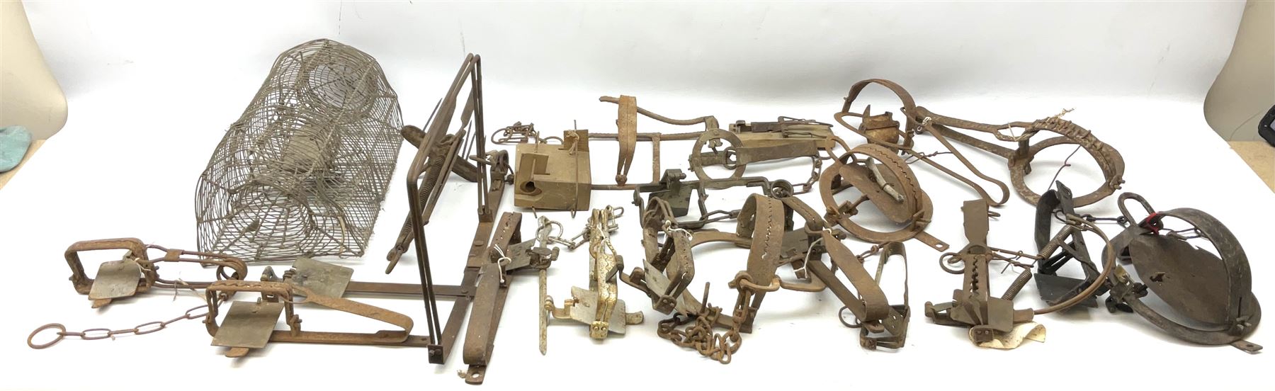 Quantity of animal traps including, gin traps, mole traps, Henri Marty wirework cage trap etc. Auctioneer's Note: These traps are sold as artefacts for ornamental purposes only as the use of some of them is illegal.