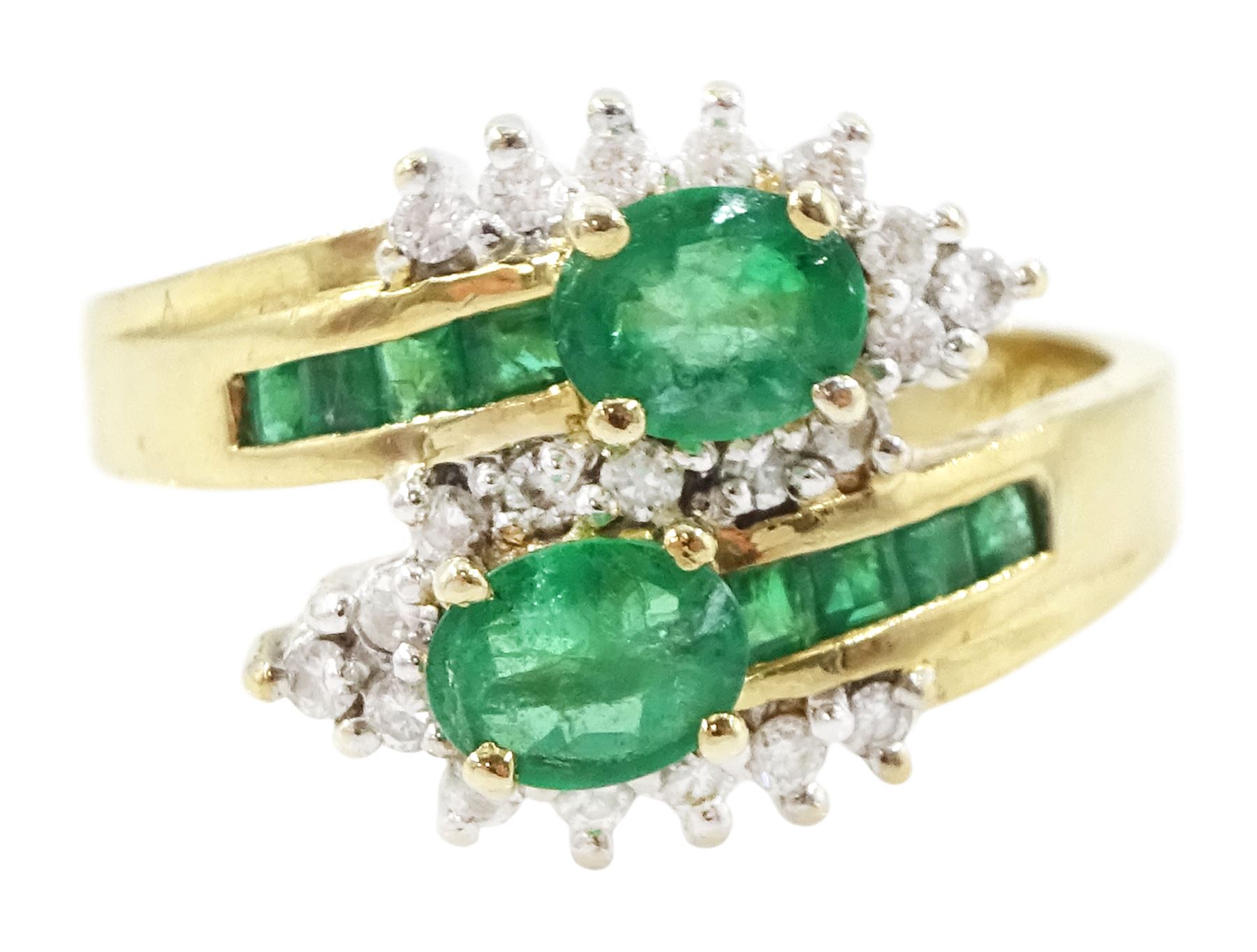 14ct gold emerald and diamond crossover ring, two oval cut emeralds with round brilliant cut diamond surround, with channel set calibre cut emerald shoulders, stamped 585
