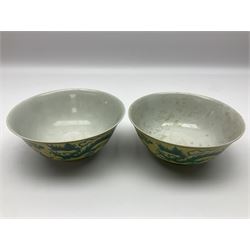 Pair of Chinese famille jaune bowls, decorated in green enamel with a dragon chasing a flaming pearl amongst clouds, upon a yellow ground, the interior decorated to centre with dragon, with six character mark beneath, D17.5cm