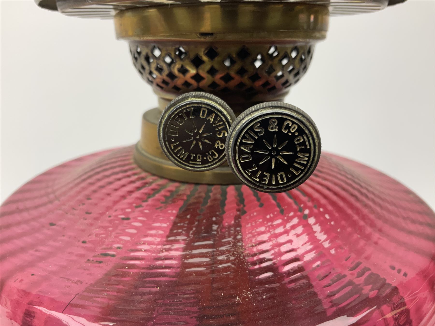 Victorian table standing oil lamp, brass fittings, cranberry glass reservoir, brass column on black enamelled ceramic base, with a frosted glass shade and clear glass chimney, H68cm