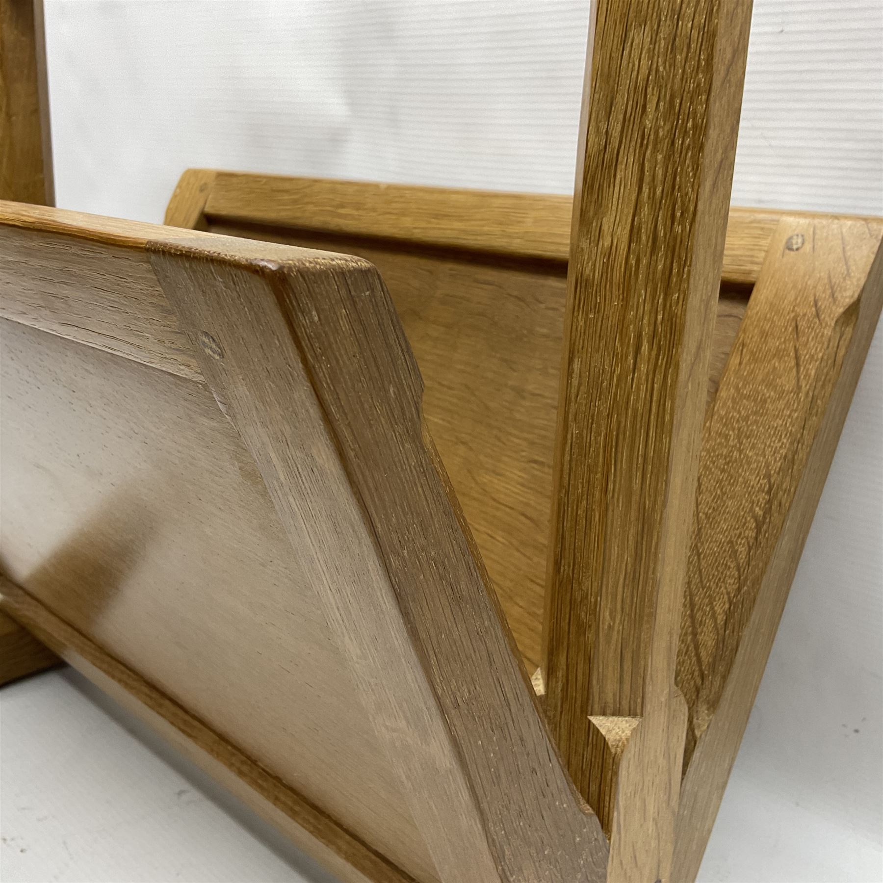 Mouseman - oak magazine rack, the top rail pierced with handle and carved with mouse signature, octagonal supports with two panelled and splayed sides, on sledge feet, by the workshop of Robert Thompson, Kilburn 