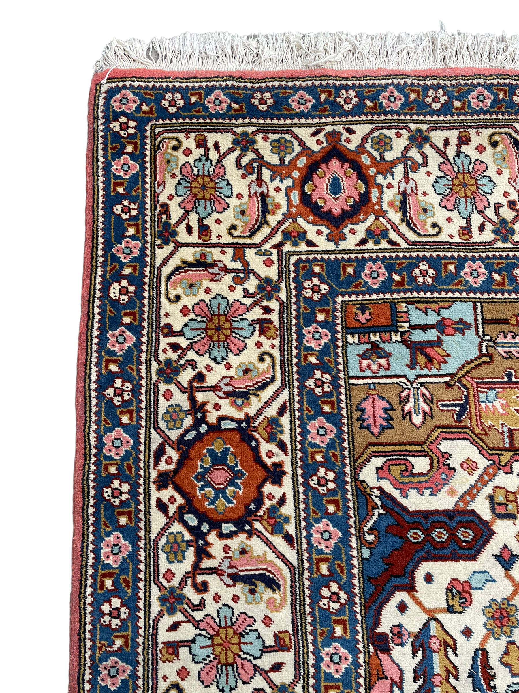 Large Persian carpet, the geometric and stylised floral medallion on rust ground field decorated with stylised plant motifs, guarded ivory border with repeating pattern