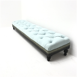 Early 20th century ebonised long low footstool, upholstered in a deep buttoned sky blue fabric, turned supports, W126cm, H20cm, D28cm