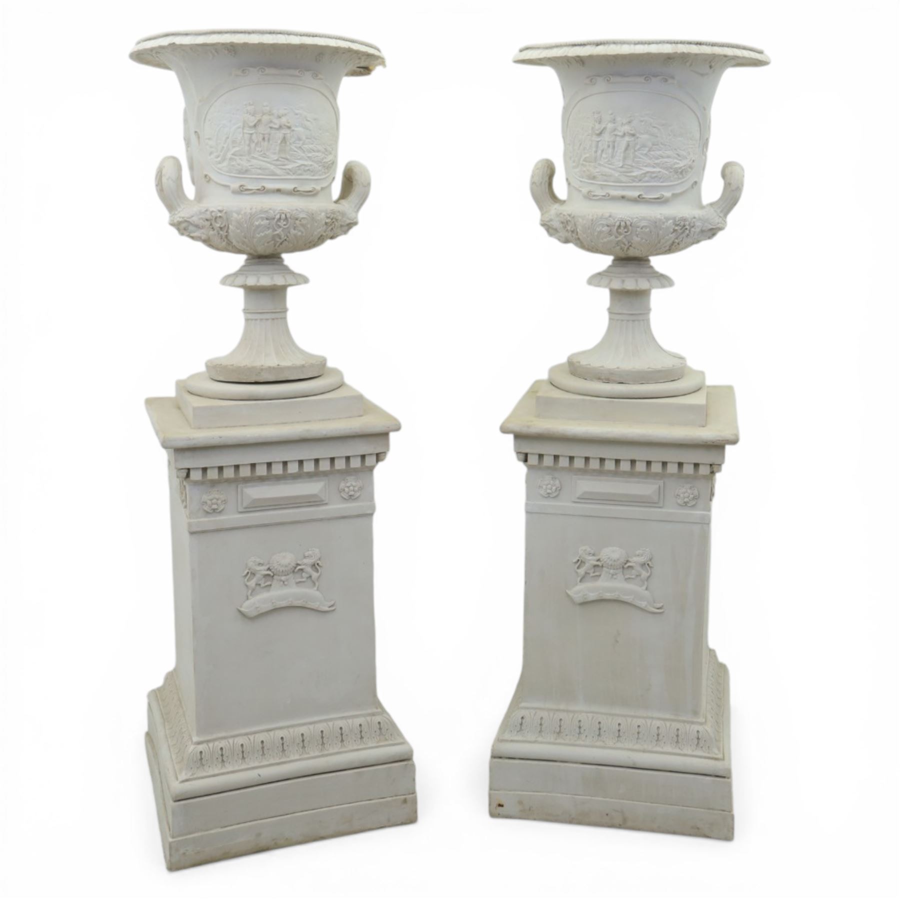 Pair of composite campana urns on stands, the urns decorated with relief figural panels and foliate bands with scrolling handles, on circular socles, the pedestals of square tapering form with moulded edges and applied classical motifs
