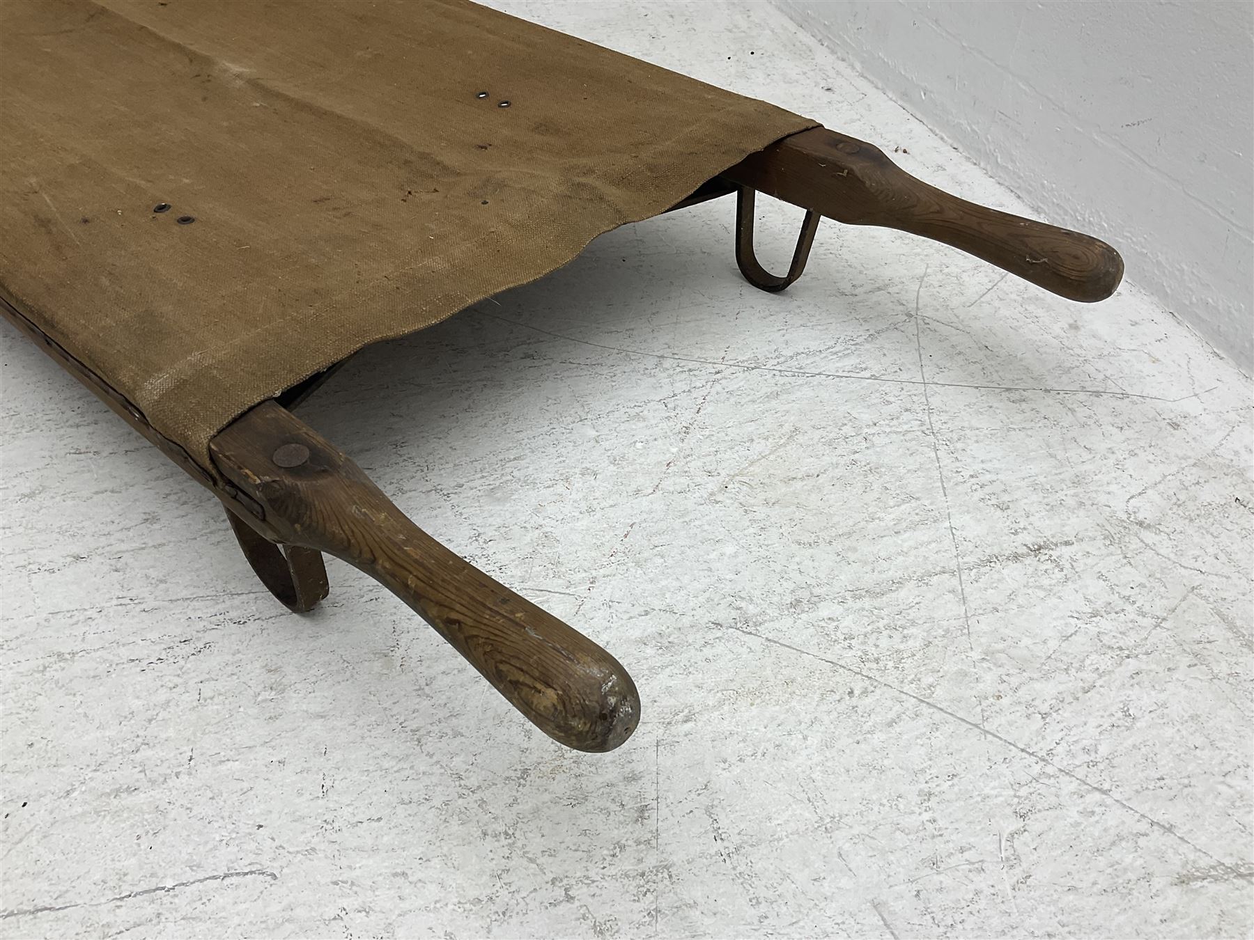 WW1 British casualty stretcher with iron mounted pitch pine sides and canvas base; stamped 'HL1917' and L7 with broad arrow in a triangle L236cm ( reputedly recovered from a barn at Bapaume on The Somme)