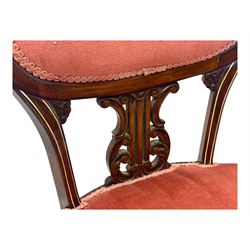 Pair of Edwardian inlaid rosewood salon chairs, upholstered in dusky pink fabric with gimp trim, oval backrest with carved crest rail with central shell motif and pierced splat, on cabriole supports terminating in castors