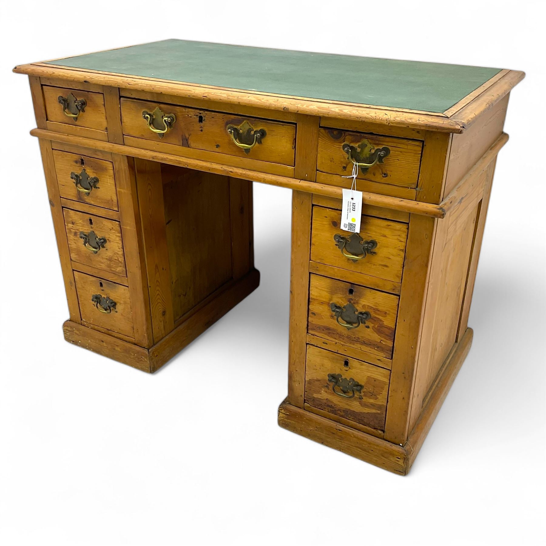 Rustic pine twin pedestal desk, rectangular green leather inset top above a central frieze drawer flanked by two short drawers, each pedestal featuring three graduated drawers, raised on a plinth base