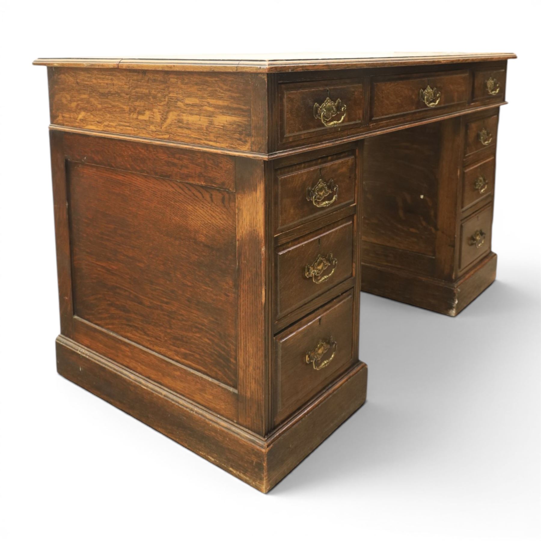 Oak twin pedestal desk with leather top, moulded rectangular top with inset black leather writing surface, nine fielded panelled drawers with brass handles, raised on a plinth base with castors