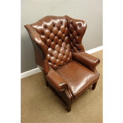  Georgian style mahogany framed high wingback club armchair, upholstered in deep buttoned brown leather, on square moulded supports with stretchers, W83cm, H114cm, D93cm  