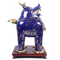Pair of 20th century foo dog incense burners, decorated with gilt flowers and insects upon a blue ground, on wooden stands, H58cm 