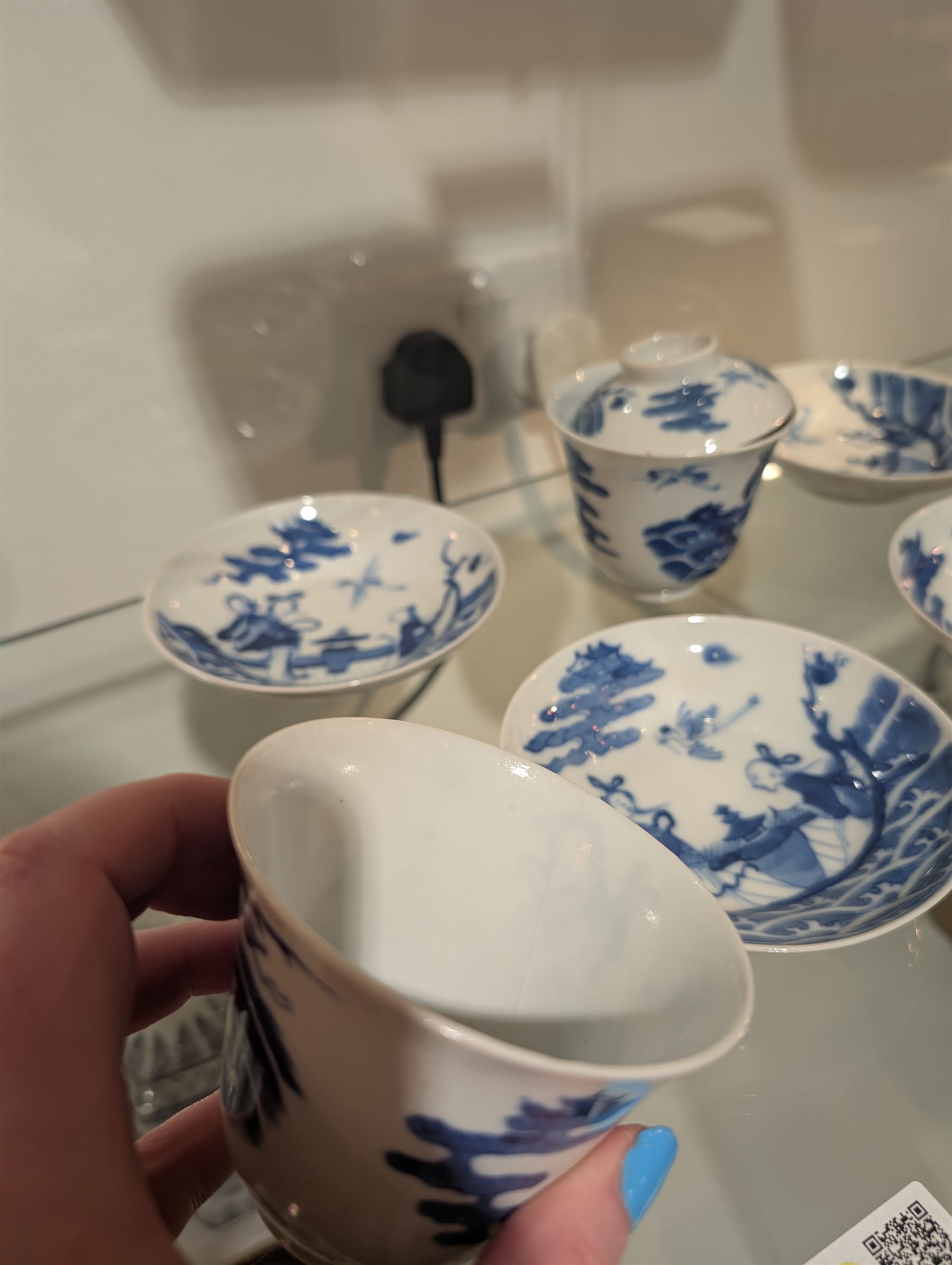 Pair of Chinese blue and white tea bowls, one with cover and four saucers, depicting two figures on a boat at sea, tea bowl H7cm