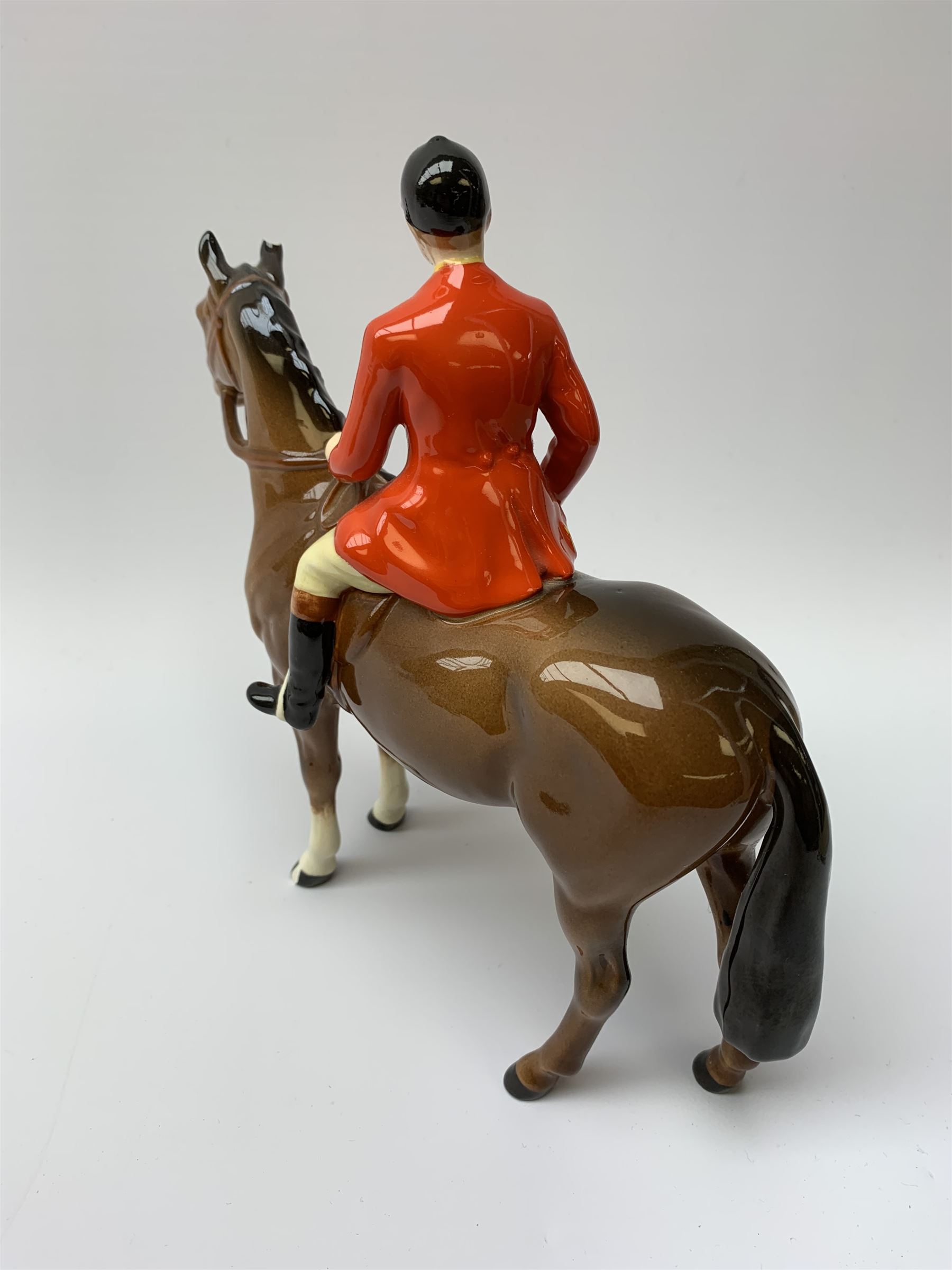 A Beswick equestrian figure modelled as a huntsman on bay horse, with printed mark beneath, together with a Beswick Norman Thelwell figure of a pony and rider, with printed mark beneath  