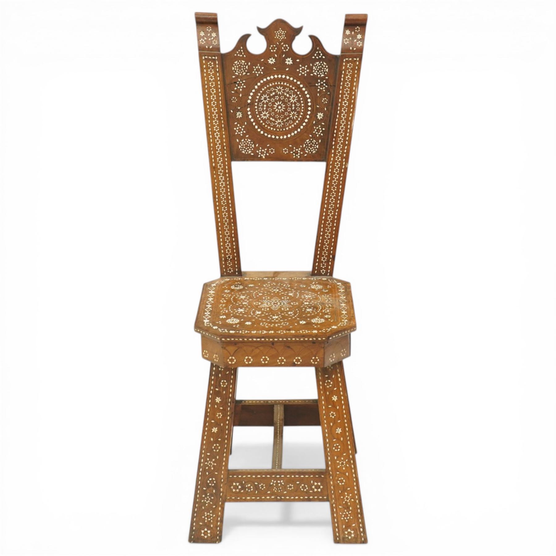 19th century Syrian olive wood and ivory inlaid chair, the shaped back and cresting above a panel centred by a circular starburst roundel within geometric and foliate marquetry and stringing, the tapering uprights and frame extensively inlaid with repeating ivory motifs, the octagonal seat similarly decorated, raised on splayed legs united by H-stretcher with further inlaid ornament