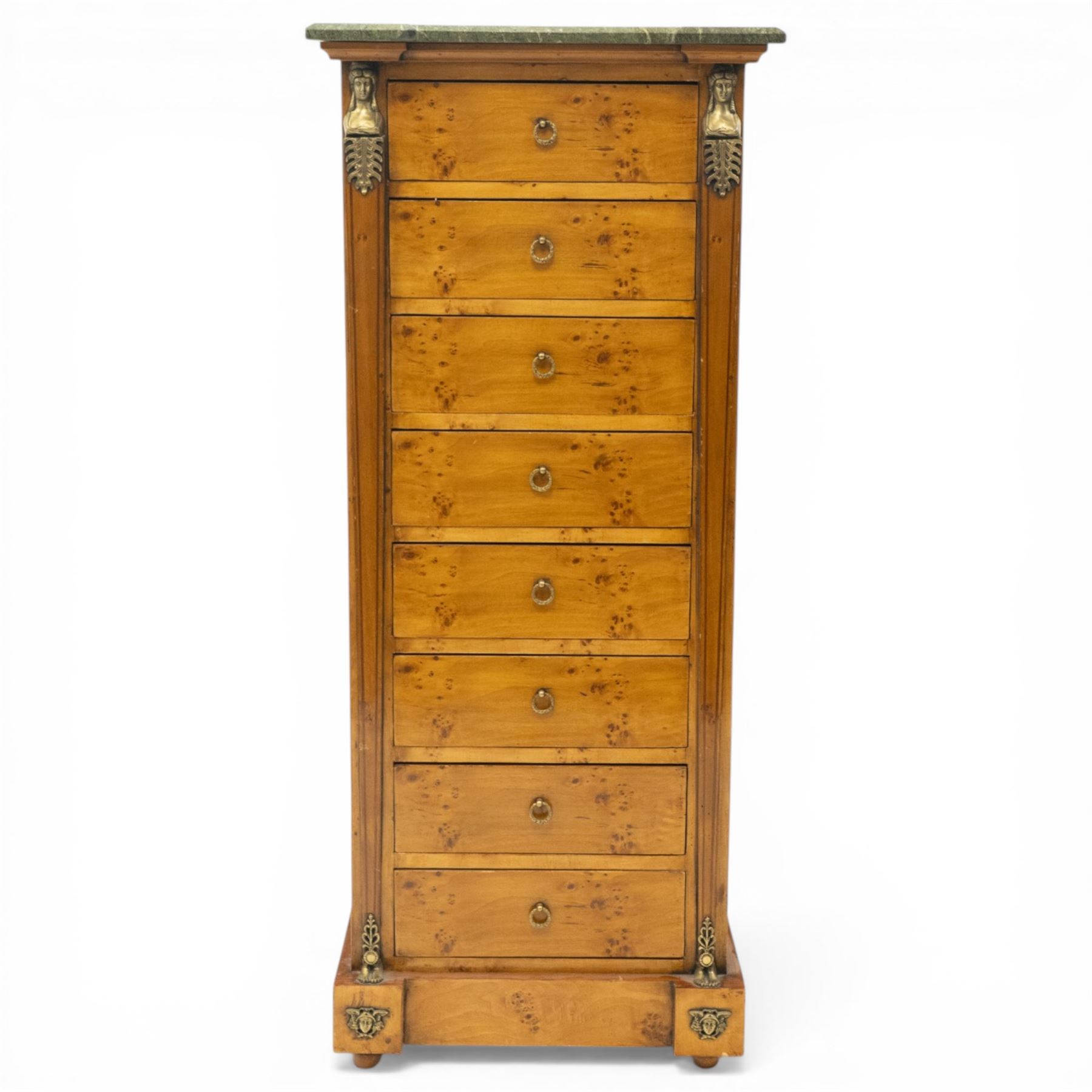 Neoclassical marble and inlaid figured maple wood tall chest, green marble inverted-breakfront top over eight long drawers, flanked by square tapering pilasters with gilt metal female bust and anthemion leaf capitals and brass feet terminals, the skirted base with applied Medusa gilt metal mounts, on compressed bun feet