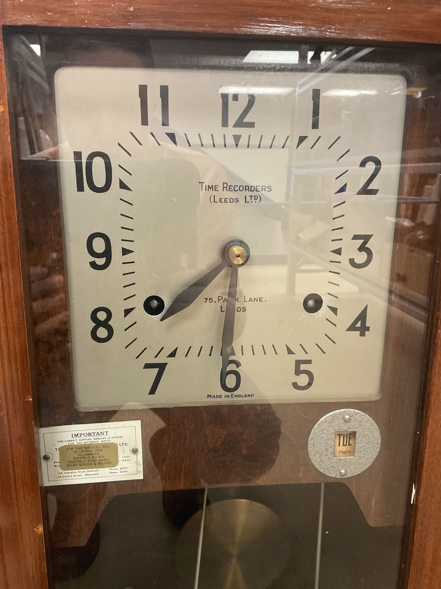 Early 20th Century Time Recorders Leeds Ltd mahogany cased clocking in machine, the square silvered dial with Arabic numerals above clocking in mechanism on plinth base, with a collection of blank clocking in cards, case H98cm