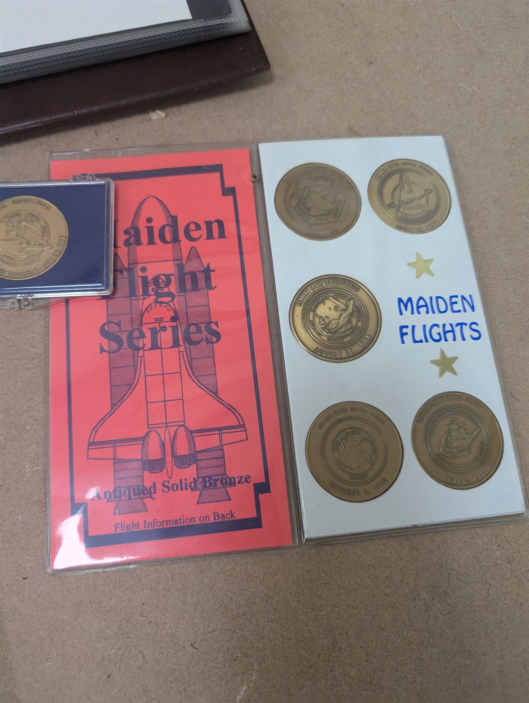 Nasa Space Shuttle program commemorative items, including album of stamp covers, telephone cards, five Shuttle Crew Emblem Collector's Series medallions, Maiden Flights bronze medallions, Missions of the Orbiter Challenger set of medallions and Apollo series medallions