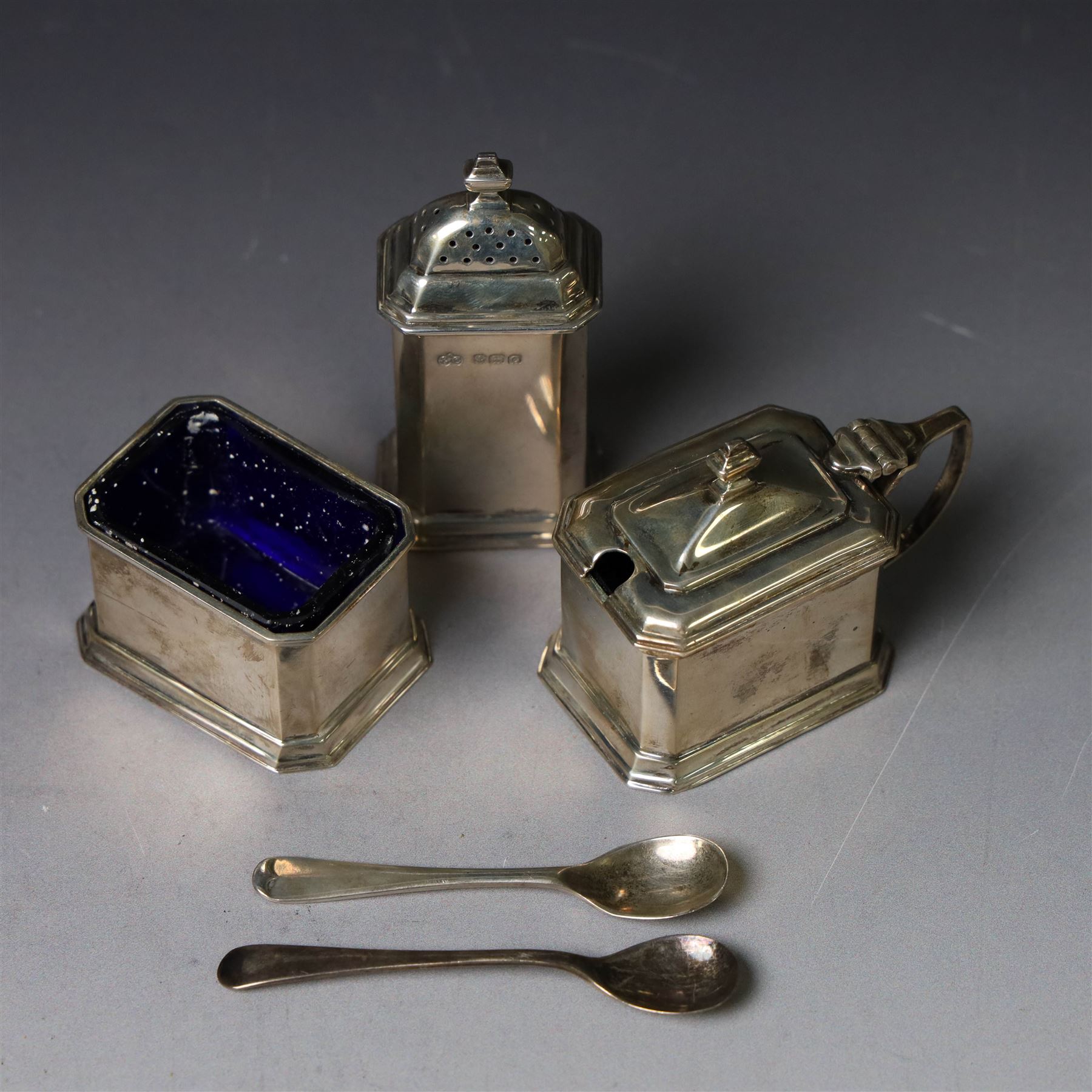 1930s silver three piece cruet set, comprising pepper shaker, open salt and mustard pot, with two matched silver spoons, together with a set of 1930s silver teaspoons, all cased and hallmarked