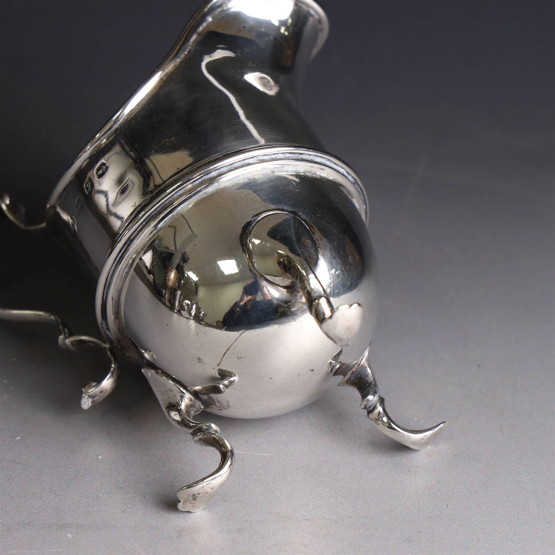 Late Victorian silver helmet shaped cream jug, with acanthus capped handle and upon three pad feet, hallmarked Birmingham 1898, maker's mark worn and indistinct, probably T Beardsmore, H10cm