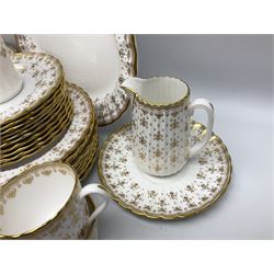 Modern Spode tea and dinner wares, decorated in the Fleur De Lys Gold pattern, comprising ten dinner plates, twelve starter plates, ten side plates, cake plate, twelve teacups, nine saucers, two jugs, sauce boat, oval platter, nine small oval dishes, condiment jar, two small bud vases, vase with flared rim, two misc saucers, and two other dishes, all with red and black printed marks beneath