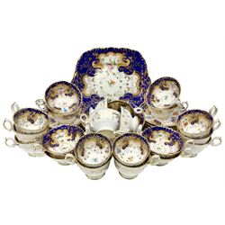 19th century porcelain part tea service, comprising twelve teacups, ten coffee cups, eleven saucers, slop bowl, and cake plate, decorated in the manner of Ridgeway or Alcock, hand painted with floral sprigs within a blue shaped border, and heightened in gilt with C scrolls and foliate detail, with painted pattern number 5954 beneath 