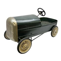 Mid 20th century pressed steel pedal car, the body painted in dark green fitted with pretend radiator to the bonnet, with spoked wheels and rubber tyres, the interior with pedals and steering wheel, L70cm