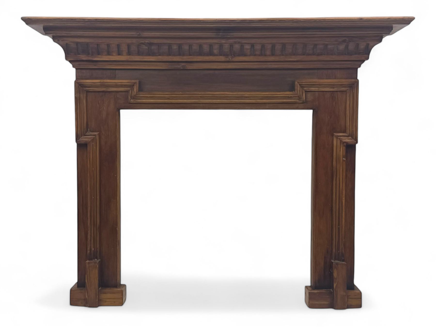 Victorian stained pine fire surround, projecting cornice with dentil moulding, panelled frieze and chamfered uprights on block supports