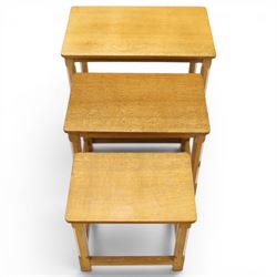 Mouseman - set of three adzed light oak nesting tables, each with rectangular top raised on octagonal legs joined by stretchers, with signature carved mouse, by the workshop of Robert Thompson, Kilburn