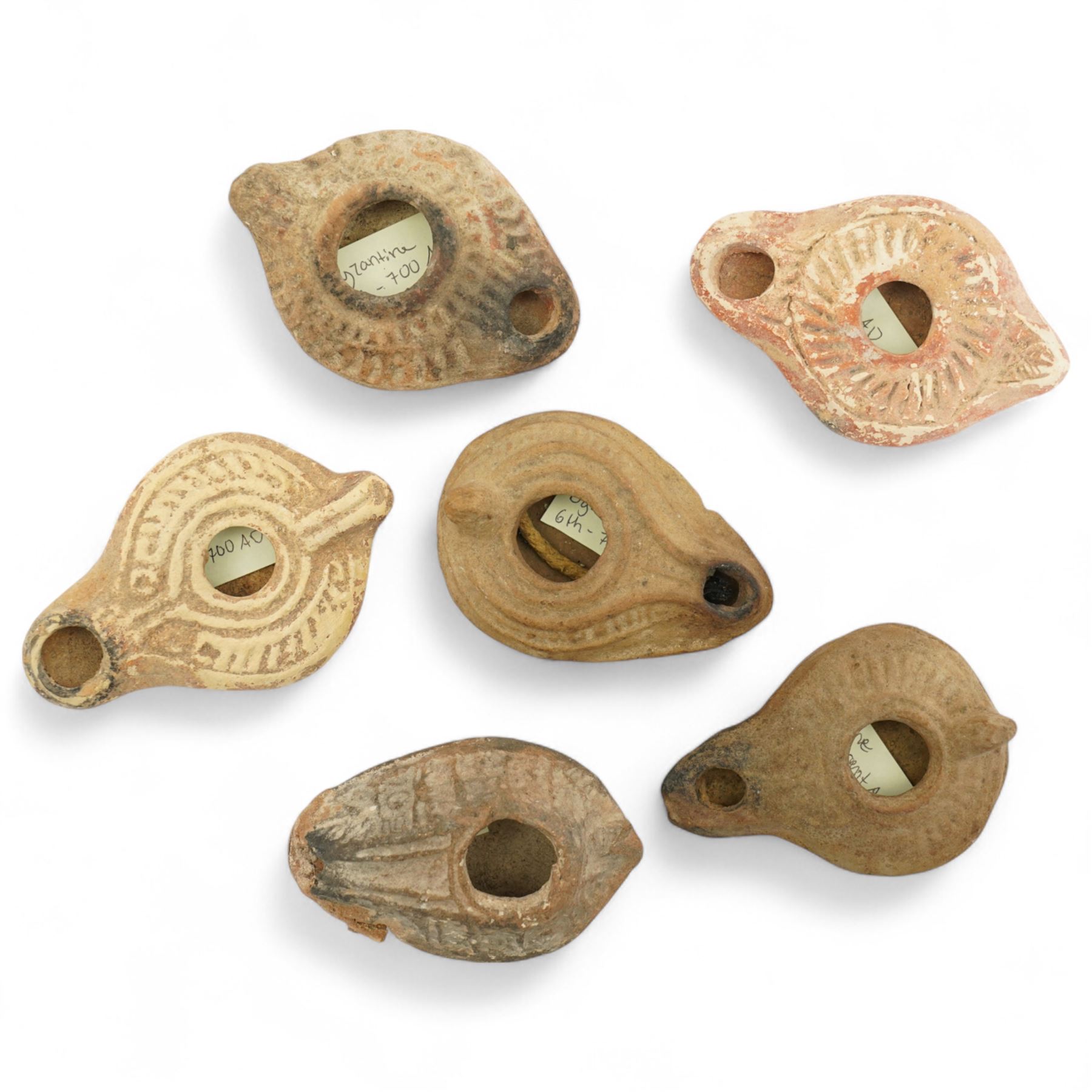 Antiquities; six Byzantine oil lamps, including terracotta examples, approximately 5th-7th century, having incised decoration, largest W10cm (6)