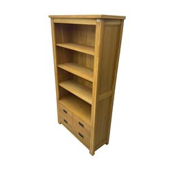 'Galloway' oak open wide bookcase, fitted with three adjustable shelves over four drawers, retailed by Alexander Ellis of Beverley