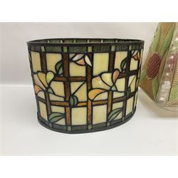 Tiffany style lamp shade, of oval form, with pale peach flowers on a cream and orange lattice ground, together with three other Tiffany style lamp shades and a moulded glass lamp shade with four coloured panels, oval Tiffany style W28.5cm