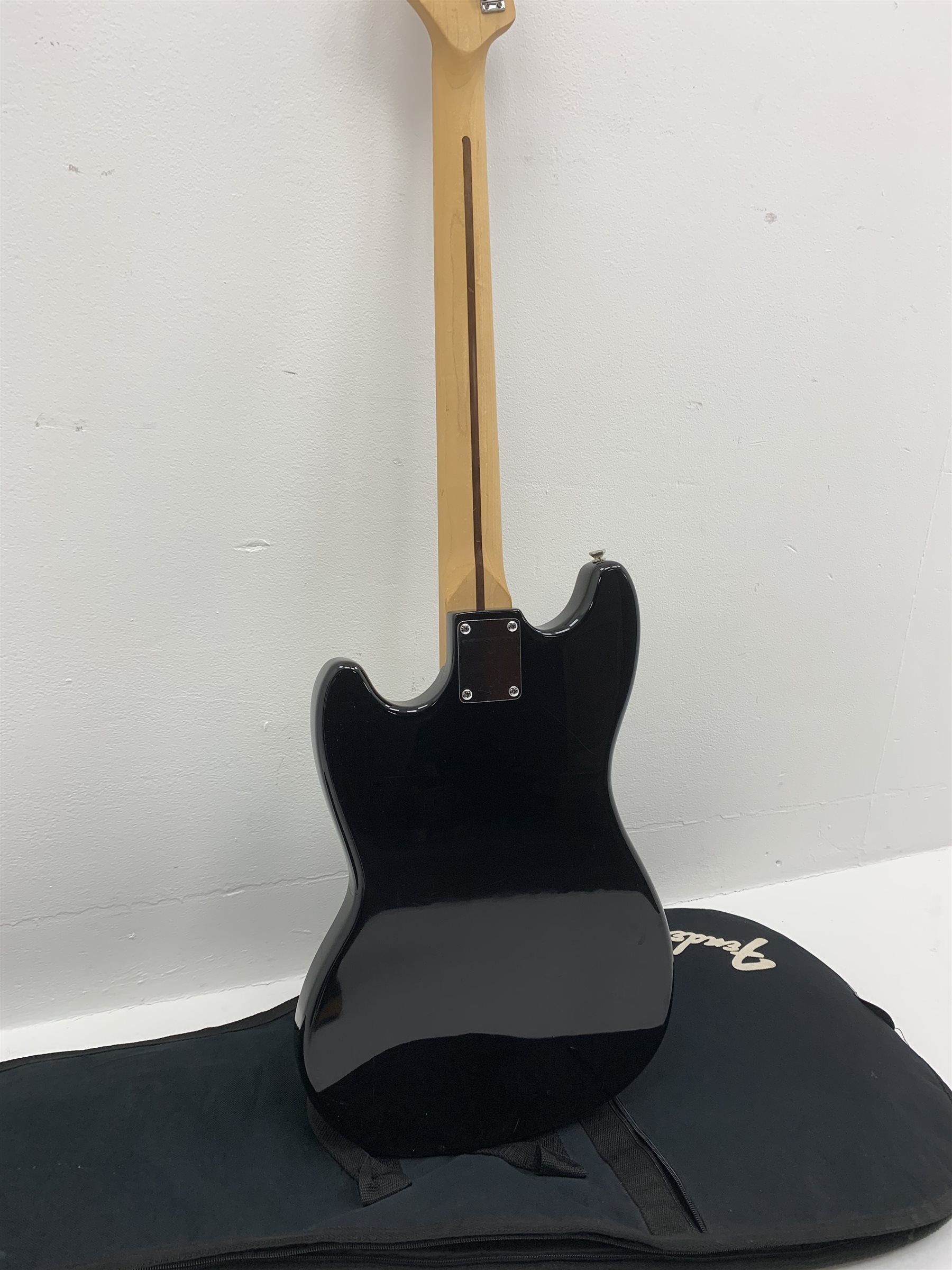  Fender Squier Bronco Affinity Series electric bass guitar, in black and white, serial no. IC021107489, L108cm, in associated Squier soft carrying case. From the collection of the late John Burgess of Beverley who played in the bands Penjants, Wine, Strollers, Revox, Sound Foundation, Pickle Belly Alley, Ragamuffins and Jerryattricks.