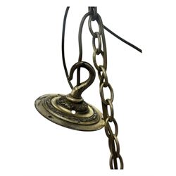 Pair of mid-20th century brass chandeliers, each with cast foliate and scroll decorated central body, issuing six scrolling arms with circular drip pans and bulb holders, suspended from integral ceiling loops