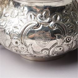 Matched three piece silver tea set comprising teapot of squat circular form London 1827,  milk jug of similar date and sugar bowl with Britannia standard marks, all with later embossed floral decoration and coat of arms, all marks rubbed