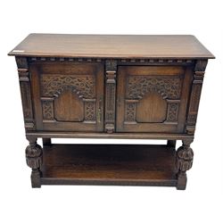 Jacobean design carved oak two door cupboard, the frieze and twin cupboard doors carved with arcaded panels and stylised foliage, raised on baluster supports united by an undertier