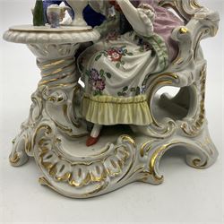 Figure group, probably Volkstedt, modelled as a courting couple seated before a table, the ornate bench and table conforming with and leading from the gilt heightened scrolling base, with blue painted mark beneath, H14.5cm
