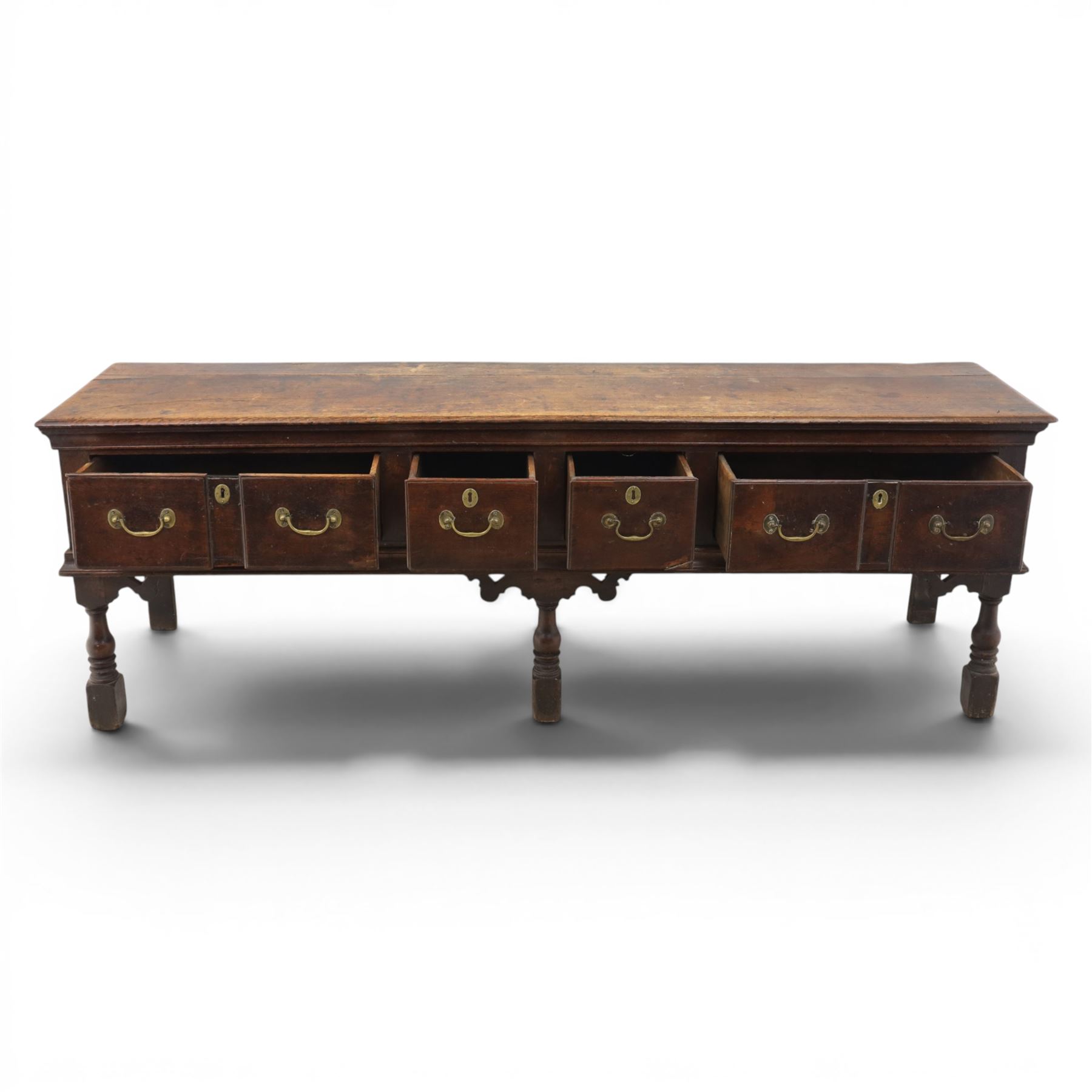 17th century 8’ oak dresser base with moulded front, rectangular top, above four drawers, raised on turned and block support 