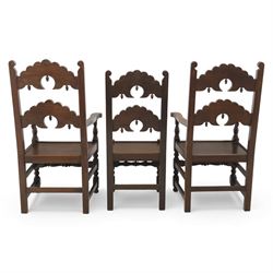 Early 20th century set of seven Jacobean Revival oak chairs, comprising pair of cavers and five chairs, each with carved mask and scroll decoration to the crest and and back rail, plain oak seat, upon turned front legs and block rear legs with conforming stretchers