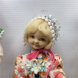 Anna Meszaros Hungary - three hand made needlewrok figurines - each wearing a lon floral dress and bonnet and holding a bouquet of flowers, tallest H32cm (3)  Auctioneer's Note: Anna Meszaros came to England from her native Hungary in 1959 to marry an English businessman she met while demonstrating her art at the 1958 Brussels Exhibition. Shortly before she left for England she was awarded the title of Folk Artist Master by the Hungarian Government. Anna was a gifted painter of mainly portraits and sculptress before starting to make her figurines which are completely hand made and unique, each with a character and expression of its own. The hands, feet and face are sculptured by layering the material and pulling the features into place with needle and thread. She died in Hull in 1998.