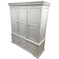 White painted triple wardrobe, projecting moulded cornice over three panelled doors, the interior fitted with hanging rails, four drawers and hinged cupboard to base, on bracket feet