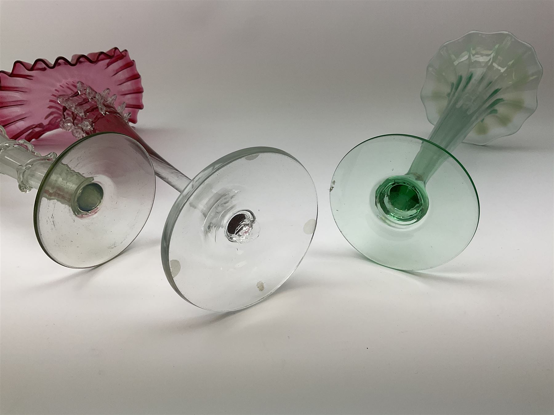 A Victorian Vaseline glass trumpet vase, with crimped rim and trailed frilled decoration, H26cm, together with a 20th century example, and a Victorian cranberry glass Jack-in-the-pulpit vase. (3). 