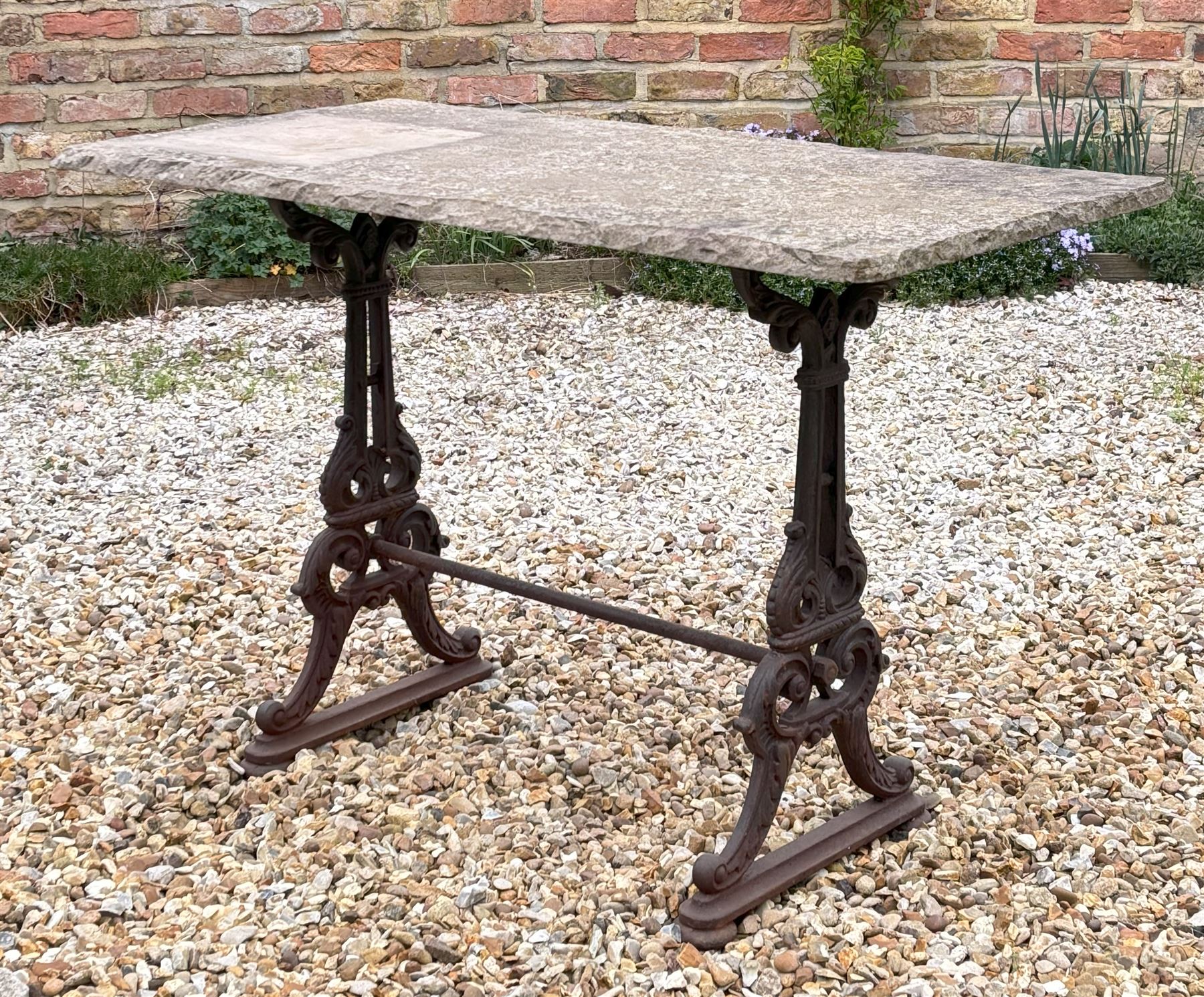 Cast iron garden table, 19th century, the stone flag top raised on end supports with kite registration mark, decorated with acanthus and united by stretcher. H75cm, L115cm, D56cm.  - COLLECTION BY APPOINTMENT FROM: The White House, Thirsk Road, Easingwold, York, YO61 3NF - CALL 01723 507111 TO ARRANGE