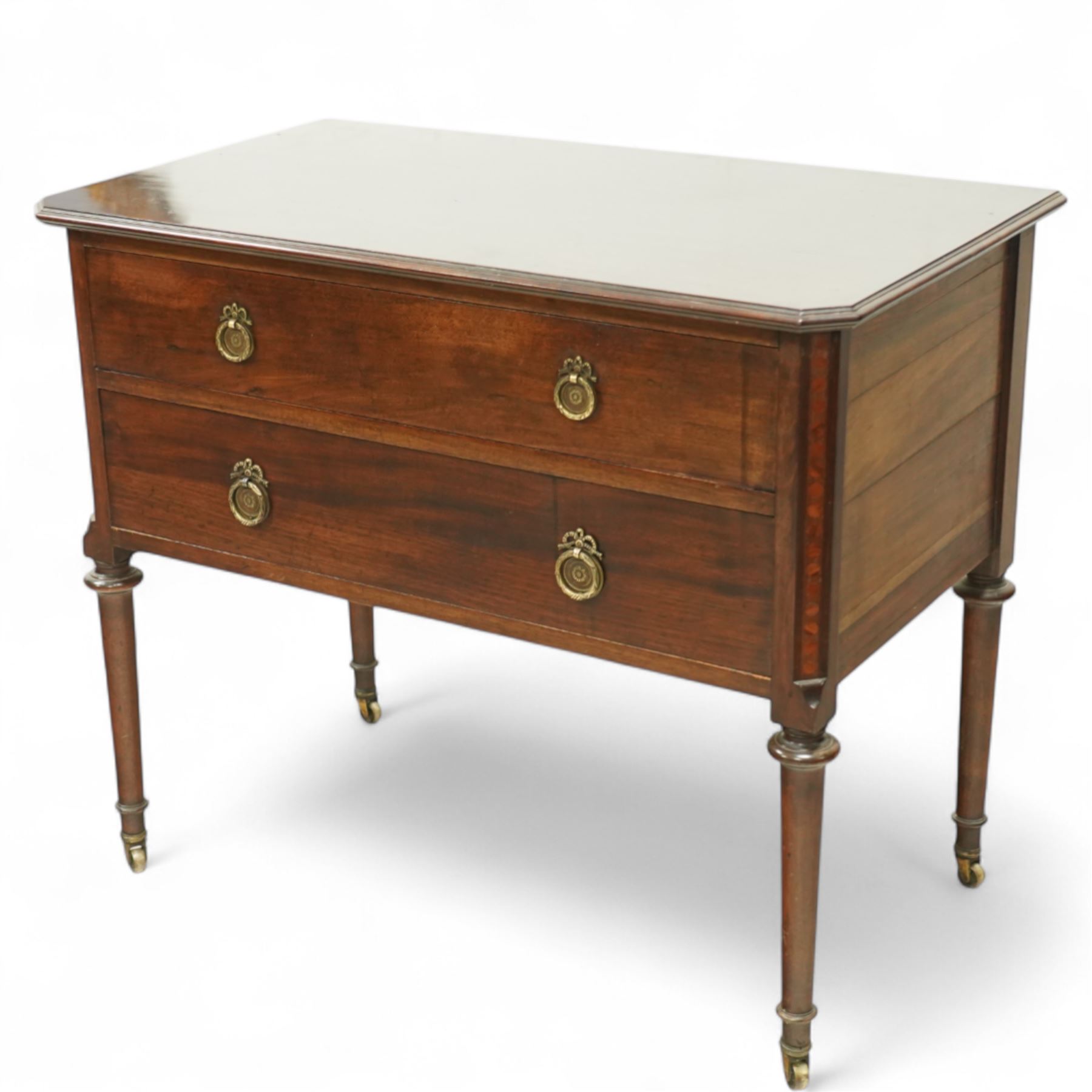 Early 20th century Regency-inspired mahogany two-drawer chest, rectangular top with moulded edge and shaped corners, above two full-width graduated drawers with ring handles, supported on turned tapered legs with brass castors                                                                                                                                                      