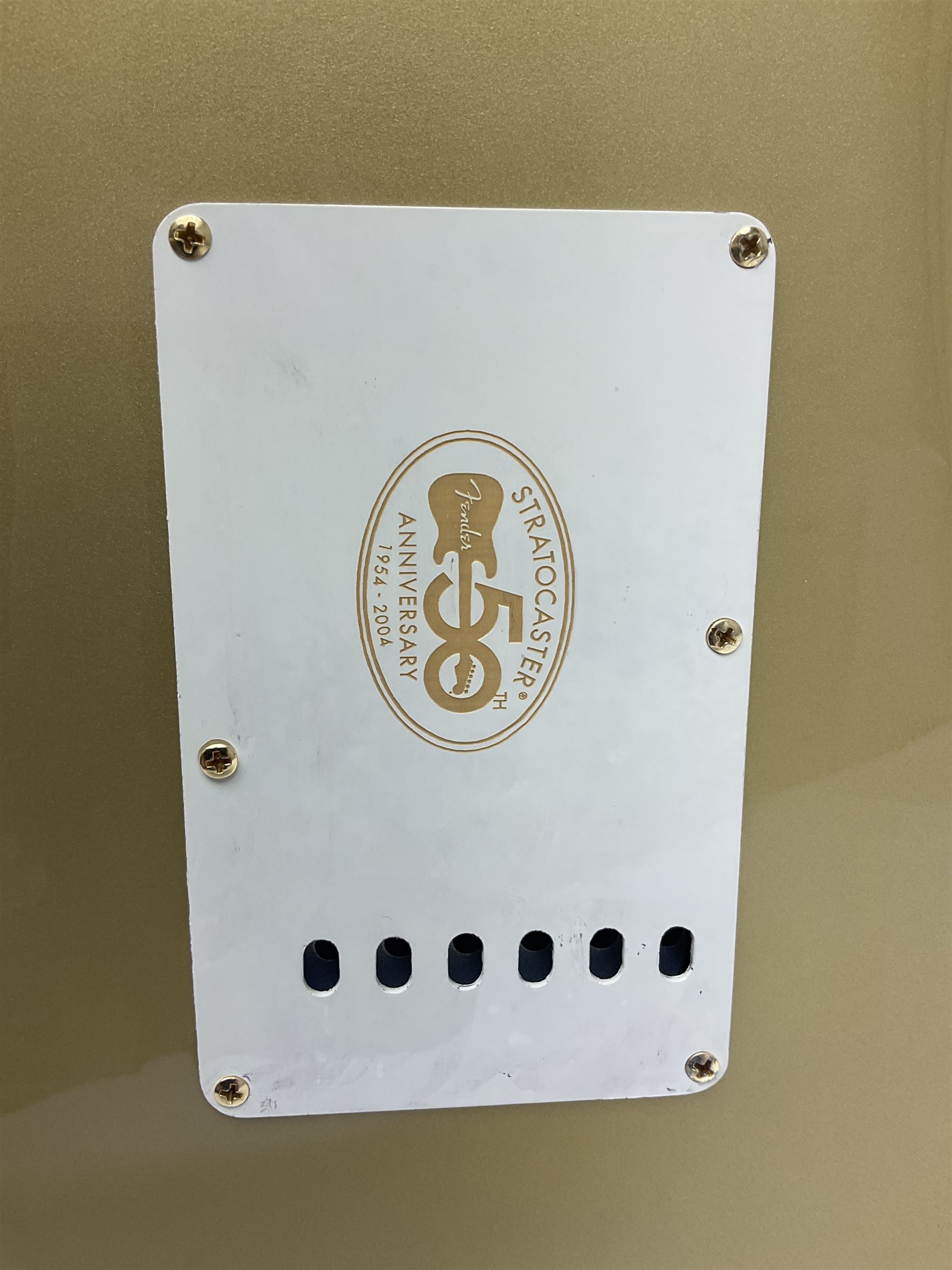 Fender Stratocaster 50th Anniversary 2004 metallic gold electric guitar; serial no.MZ4116369; L98cm; in Spider fitted case with owners manual and other paperwork, strap and belt buckle etc