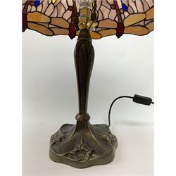 Tiffany style table lamp, with cast spreading base detailed with flowers, and leaded glass shade detailed with dragonflies, overall H54cm