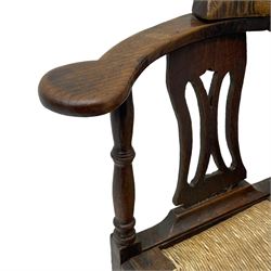18th century country elm and oak corner chair, the shaped cresting rail terminating to swept arm resets, supported by turned columns and pierced shaped splats, over a drop-in rush seat, raised on square supports united by box stretcher