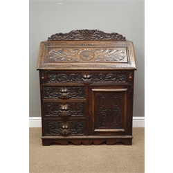  Victorian oak bureau, fall front above four drawers and cupboard, heavily carved with acanthus leaf scrolls and mask handles, W91cm, H111cm, D49cm  