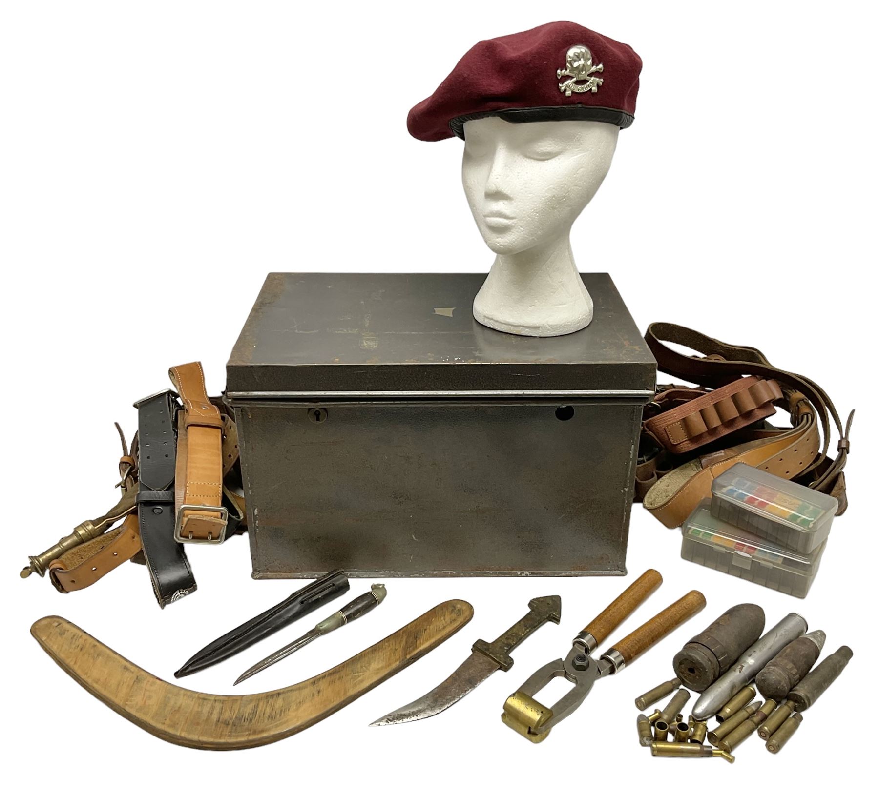 Assorted militaria including ten leather or canvas cartridge and other belts, maroon beret with 17th Lancers cap badge, modern bullet mould, leather and brass shot flask, two knives, shell cases, boomerang etc; in tin deed box