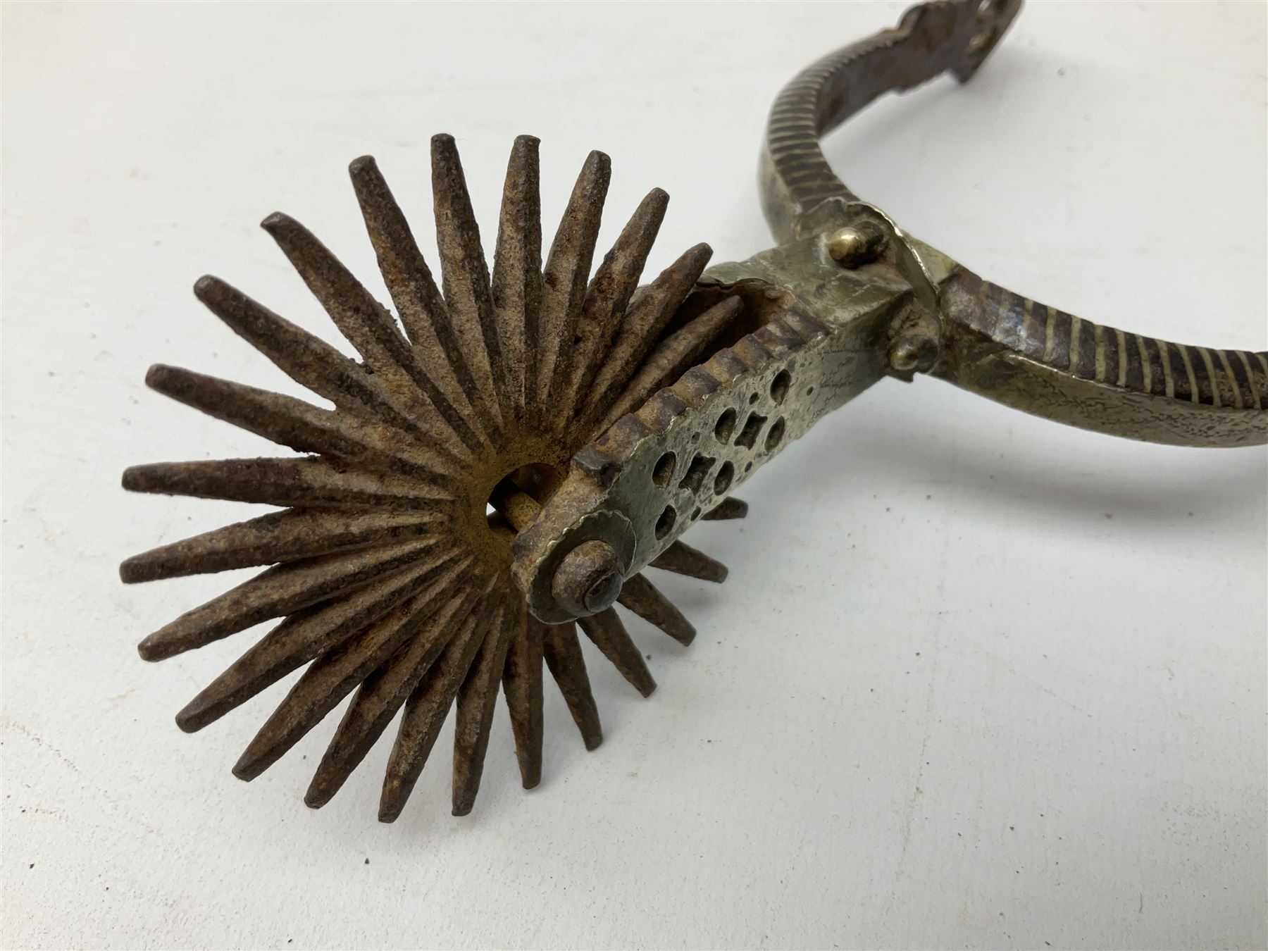 Pair of late 19th century South American iron spurs, engraved silver mounts, with sunburst rowls