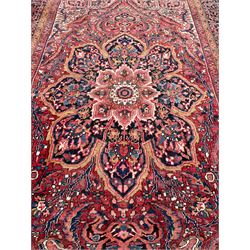 Antique Persian coral ground carpet, the large central floral pole medallion with extending foliate designs, the thick guarded indigo border with repeating flower heads and circles